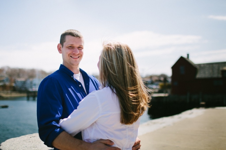 Man smiling while engaged couple embraces in Rockport MA