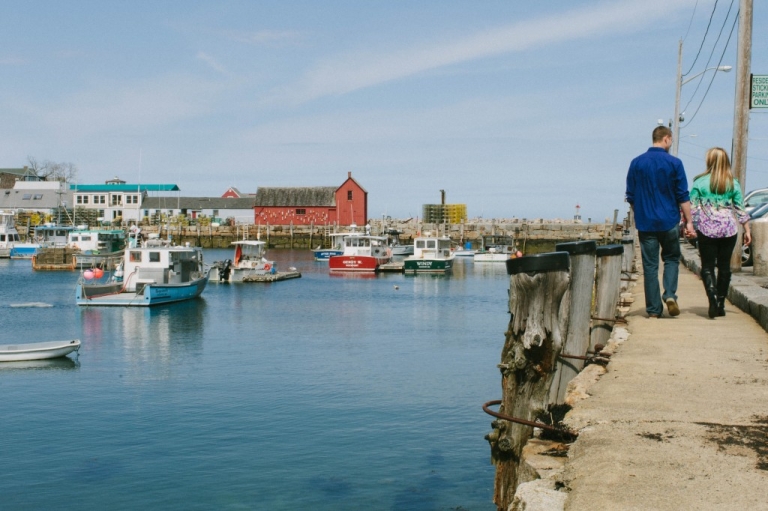 Engaged couple walking along the water in Rockport