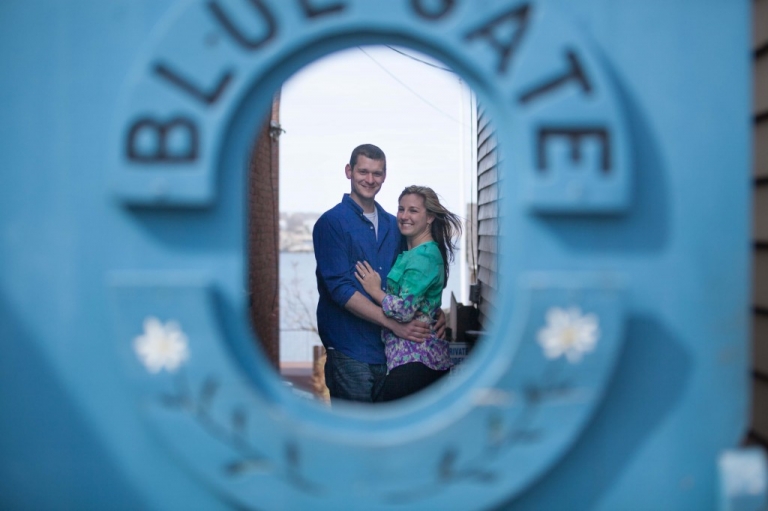 Couple inside keyhole of blue gate in Rockport 