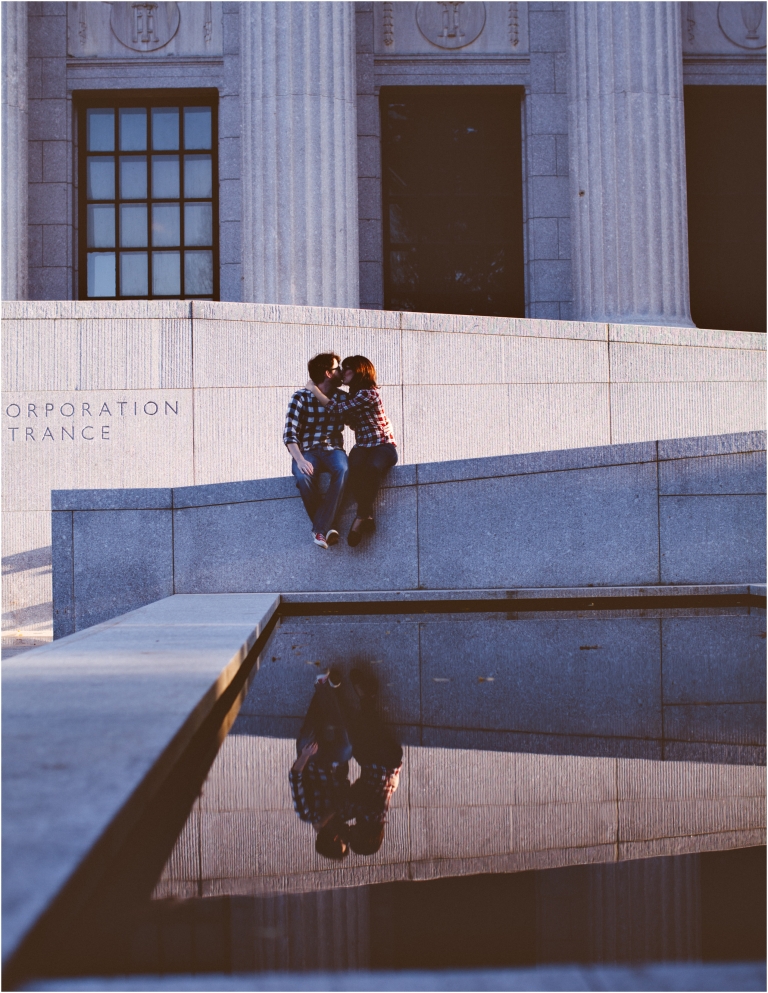 Engaged couple kissing with a reflection in pool at back entrance of Boston MFA