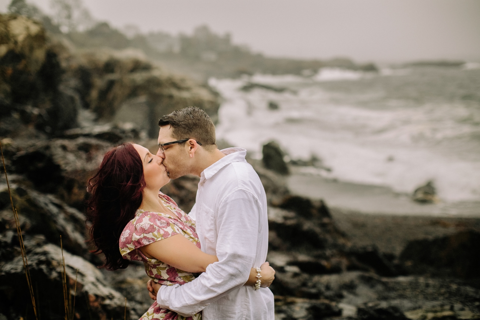 Engaged couple kissing on Marblehead Coast