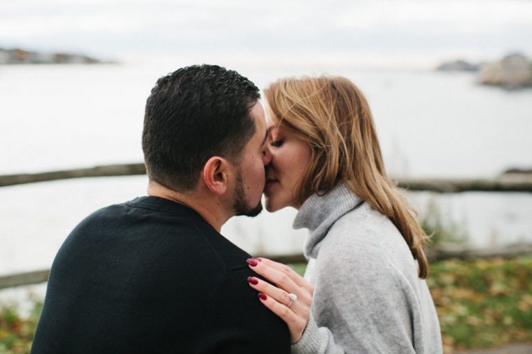Engaged couple kiss during engagement shoot at Fort Sewell Marblehead Massachusetts