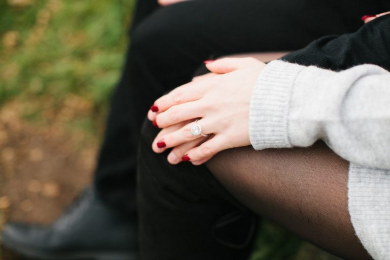 Newly engagement woman wearing pear-shaped diamond engagement ring during engagement session in Marblehead, Massachusetts