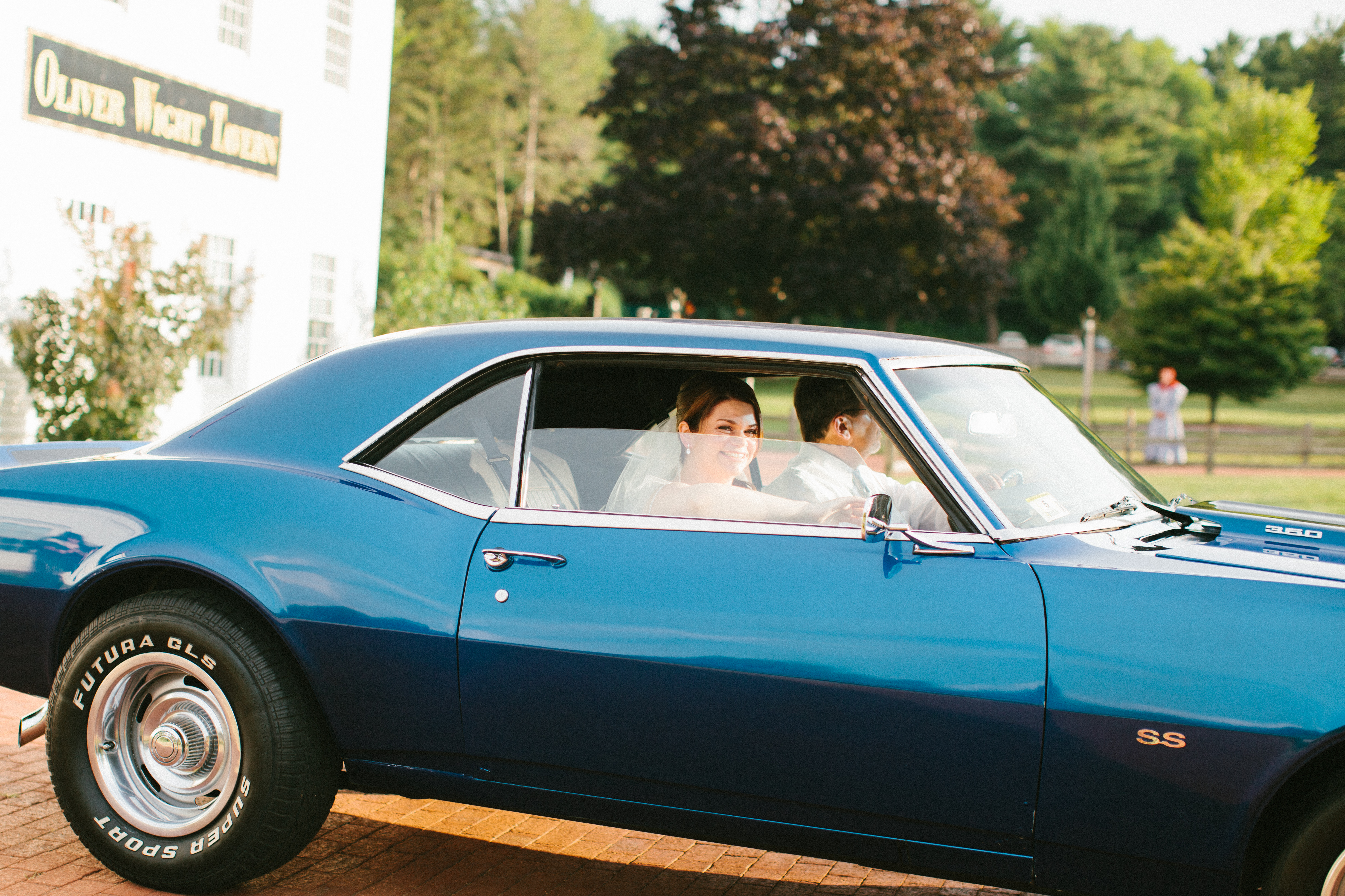 Bride arrives at her wedding in a classic blue mustang